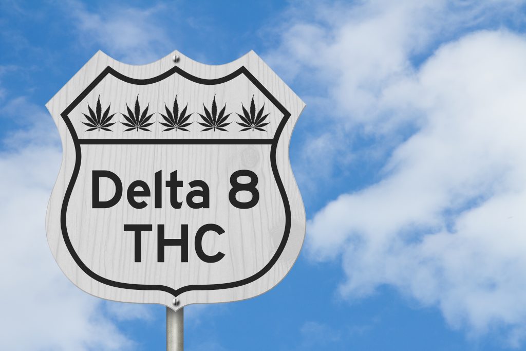 Delta 8 THC message with cannabis leaves on a American highway sign with sky