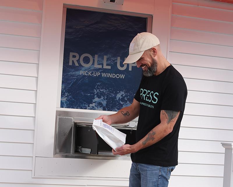 shore house canna delivery worker collecting at roll up window